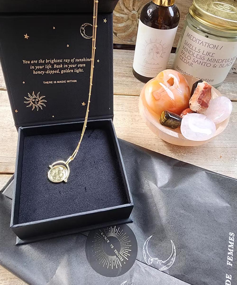 Gold Manifesting As Above So Below Spinner Necklace in black jewellery box.