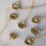 Gold Manifesting As Above So Below Spinner Necklace on marble.