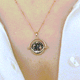 Gold Manifesting As Above, So Below Spinner Necklace worn by woman spinning from sun to moon side.