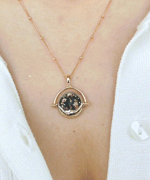 Gold Manifesting As Above, So Below Spinner Necklace worn by woman spinning from sun to moon side.