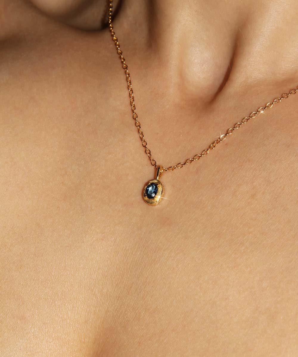 Maison de Femmes gold vermeil September Sapphire Birthstone Necklace worn by woman.