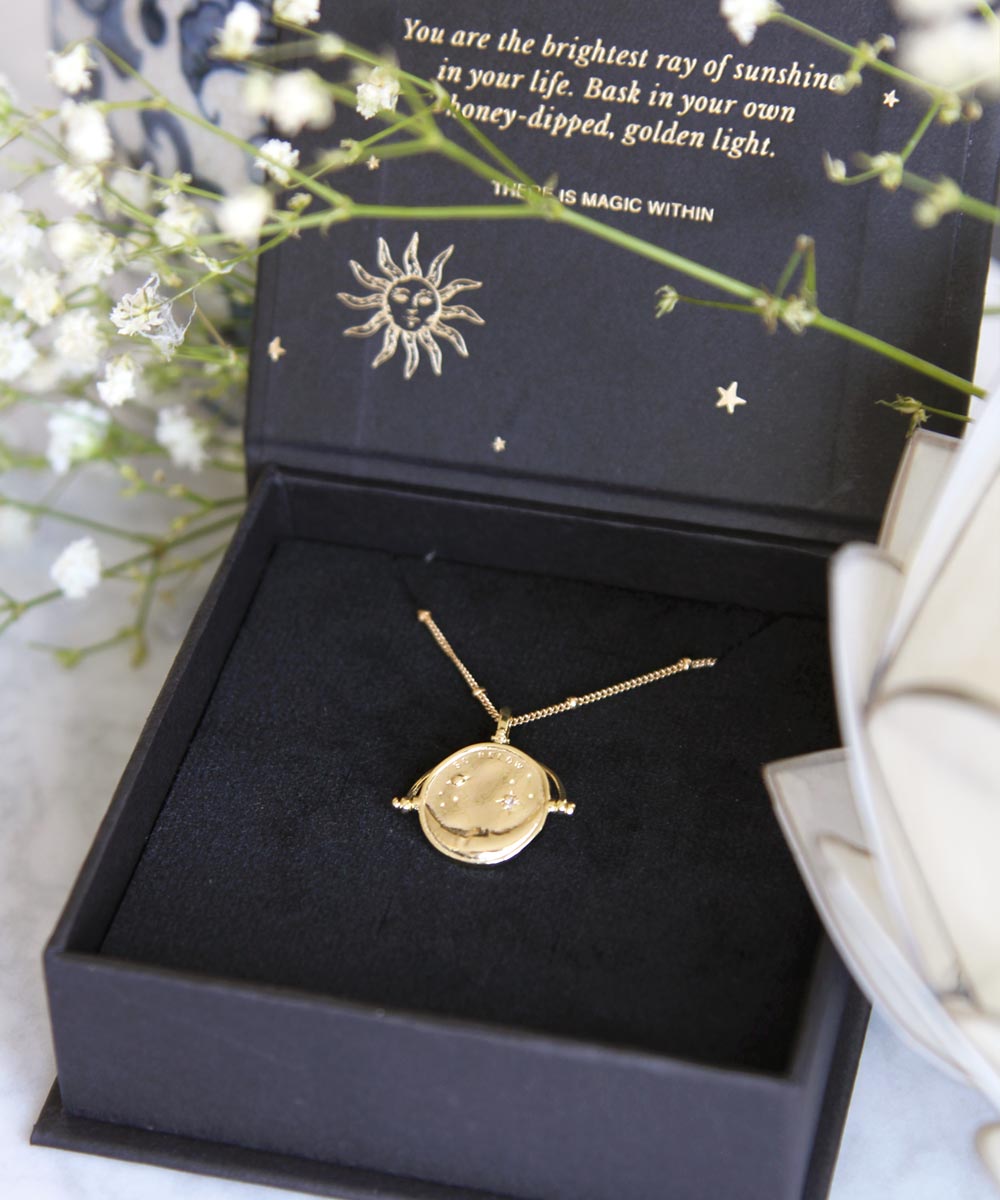 Gold Manifesting As Above So Below Spinner Necklace in black jewellery box.