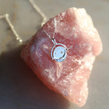 Sterling Silver Manifesting As Above So Below Spinner Necklace resting on rose quartz crystal stone.