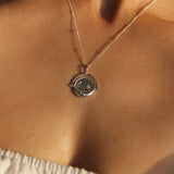 Sterling Silver Manifesting As Above So Below Spinner Necklace worn by woman.