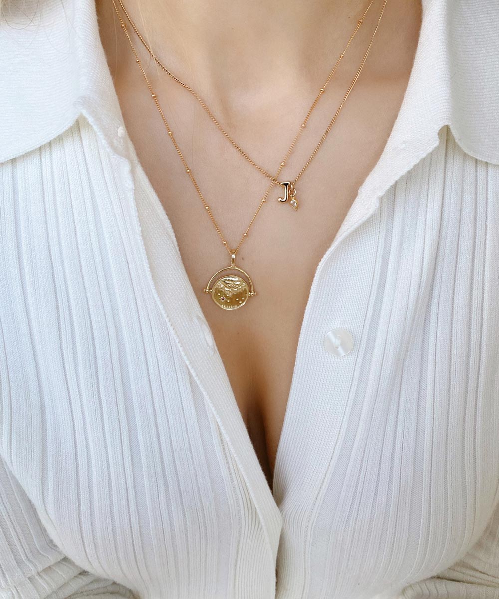 Gold Manifesting As Above So Below Spinner Necklace worn by woman with a J Initial + Birthstone Charm Necklace.