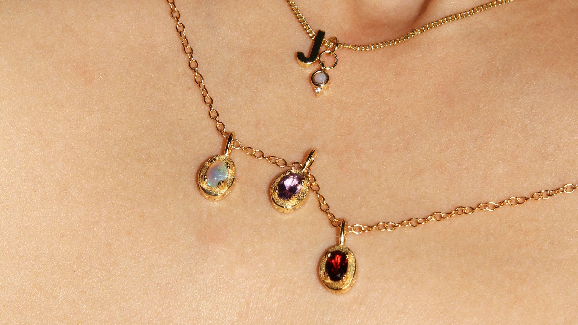 Maison de Femmes gold vermeil October Opal, February Amethyst, January Garnet Birthstone Necklace worn by woman. Stacked with J Initial and October Opal Mini Birthstone