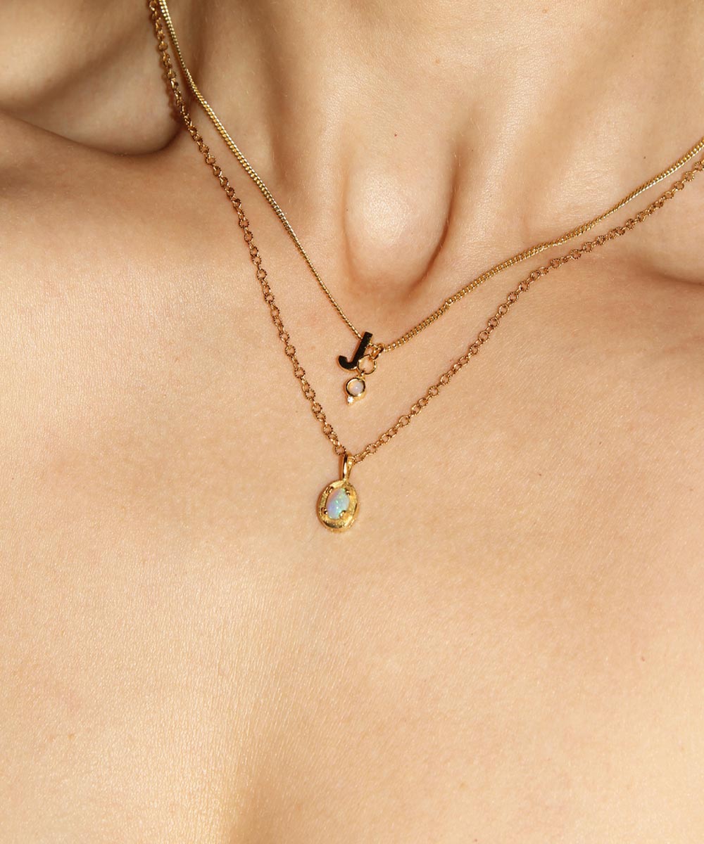 Opal Birthstone Pendant Necklace stacked with J Initial and mini Opal Birthstone Charm worn by woman.