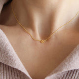 Maison de Femmes gold vermeil petite four leaf clover necklace worn by woman.