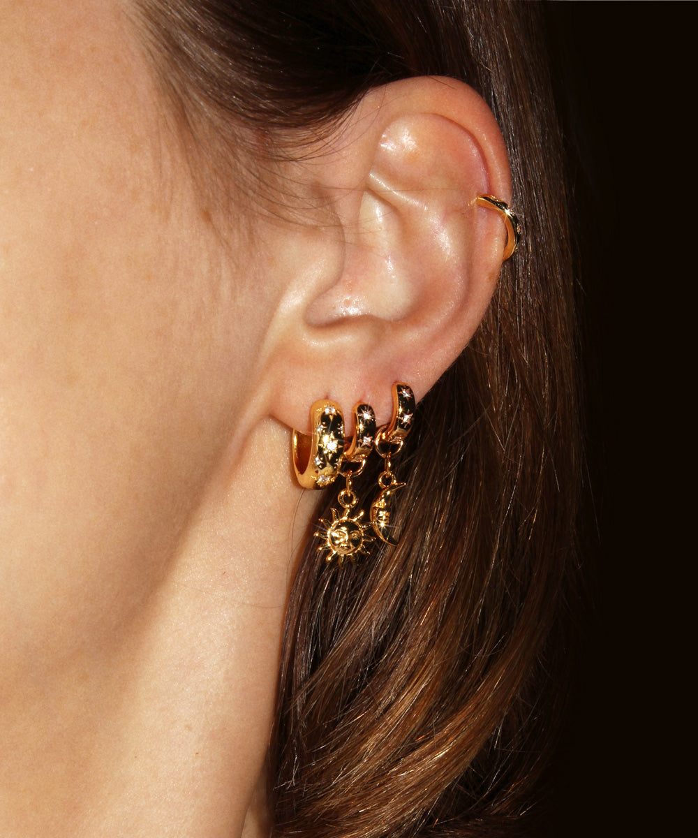 Star Studded Cosmic Celestial Hoop Earrings from the Maison de Femmes Galaxia Collection with sun and moon charms worn by woman.