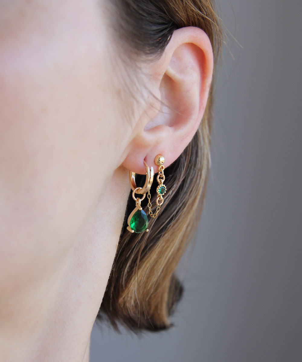 Green earrings set worn by woman.