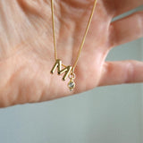 M Initial and April Birthstone Charm held by hand.
