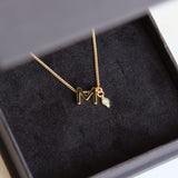 M Initial and Opal Birthstone Charm Necklace in black box.