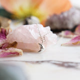 Maison de Femmes Sterling Silver Croissant Charm Necklace on rose quartz stone.