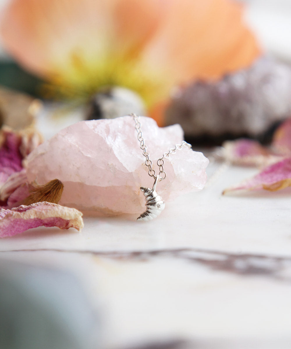 Maison de Femmes Sterling Silver Croissant Charm Necklace on rose quartz stone.