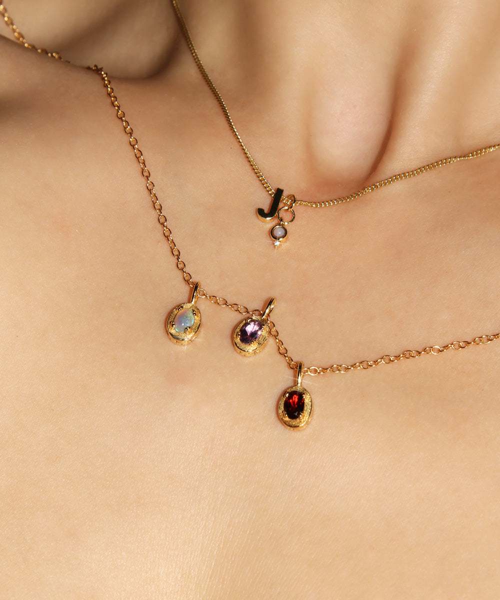 Maison de Femmes gold vermeil October Opal, February Amethyst, January Garnet Birthstone Necklace worn by woman. Stacked with J Initial and October Opal Mini Birthstone