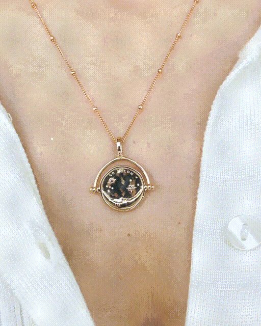 Gold Manifesting As Above, So Below Spinner Necklace worn by woman spinning from sun to moon side.