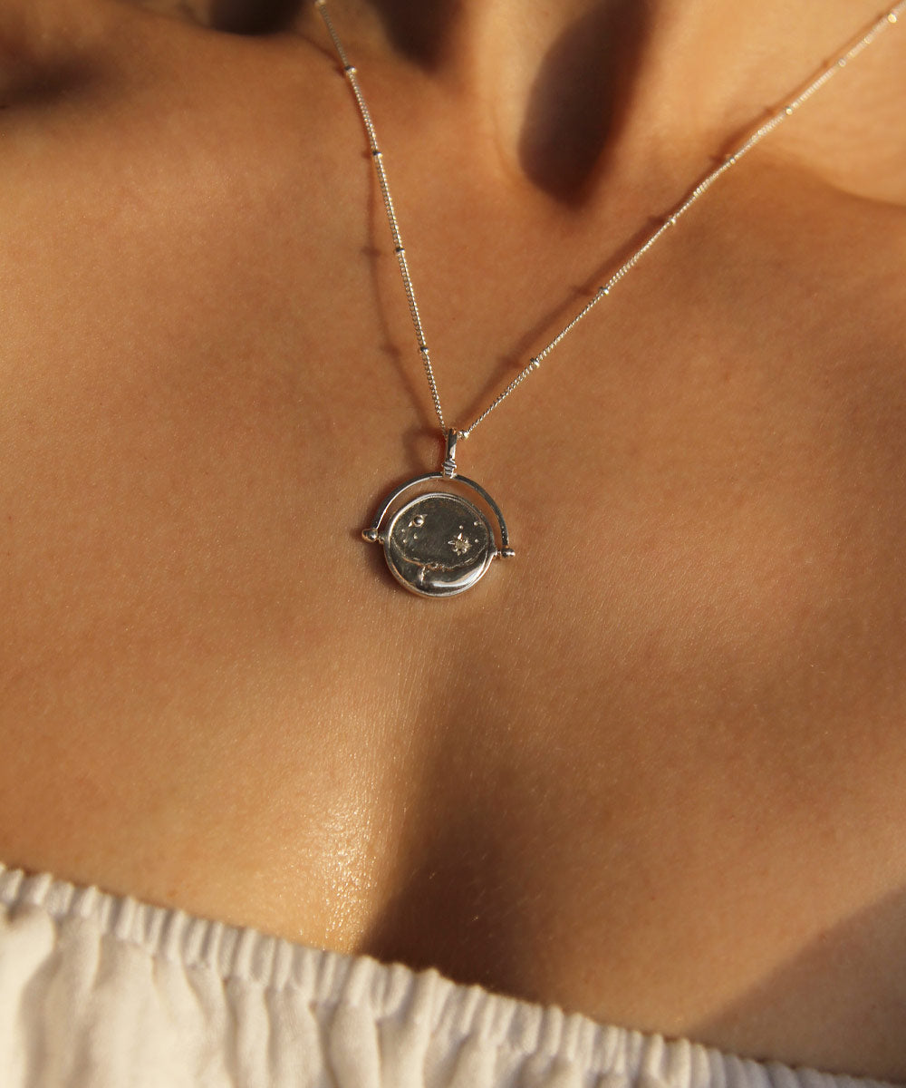 Sterling Silver Manifesting As Above So Below Spinner Necklace worn by woman.