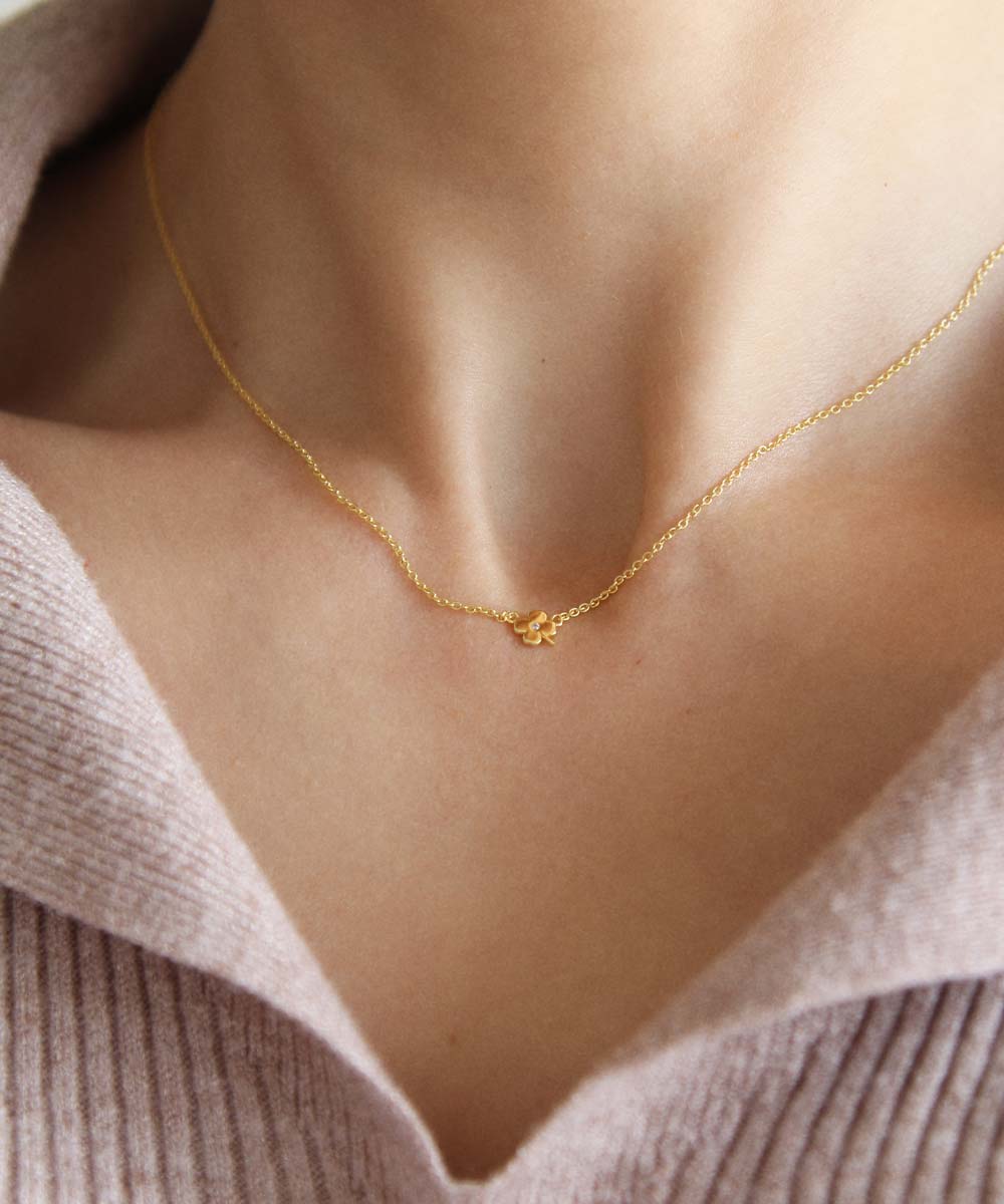 Maison de Femmes gold vermeil petite four leaf clover necklace worn by woman.