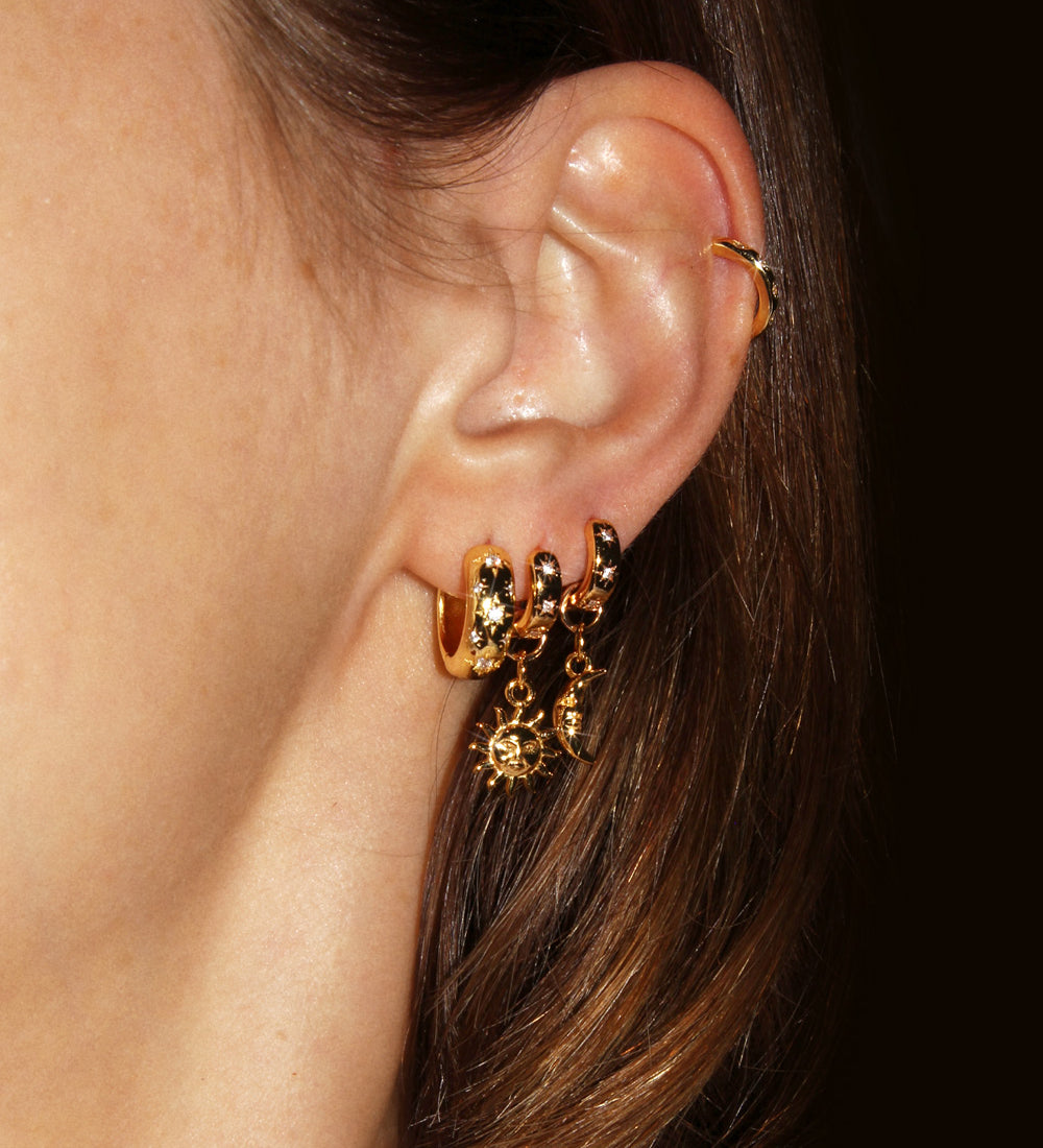 Star Studded Cosmic Celestial Hoop Earrings from the Maison de Femmes Galaxia Collection with sun and moon charms worn by woman.