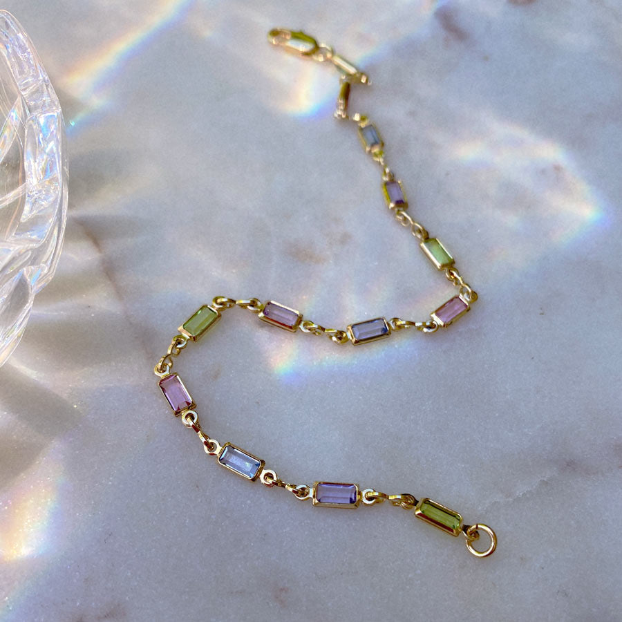 Maison de Femmes gemstone bracelet on marble background with refracted light and crystal
