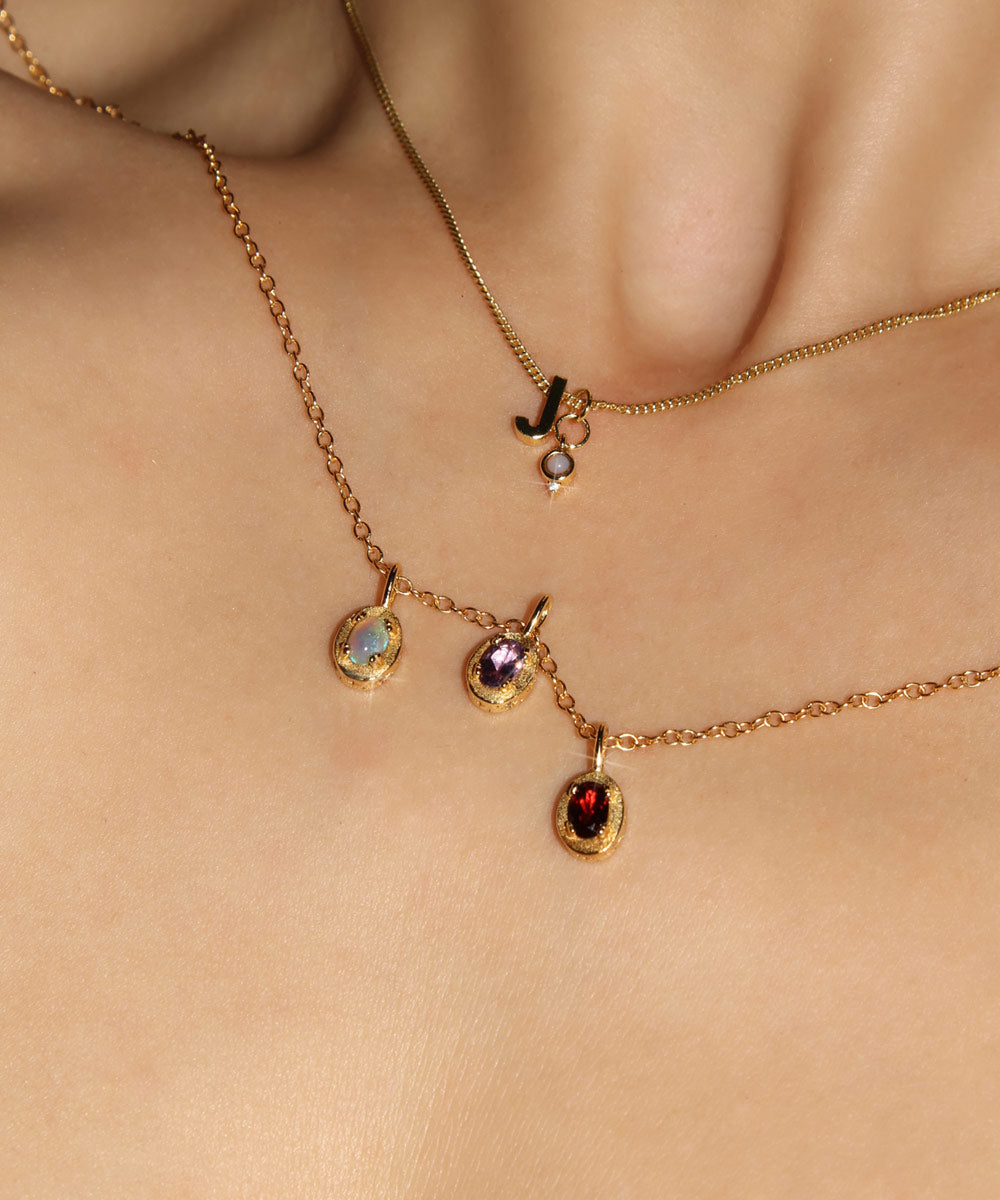 Maison de Femmes gold vermeil October Opal, February Amethyst, January Garnet Birthstone Necklace worn by woman. Stacked with J Initial and October Opal Mini Birthstone