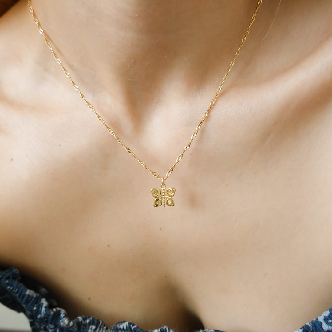 Australian gold filled jewellery butterfly charms with cosmic etchings on necklace worn by girl.
