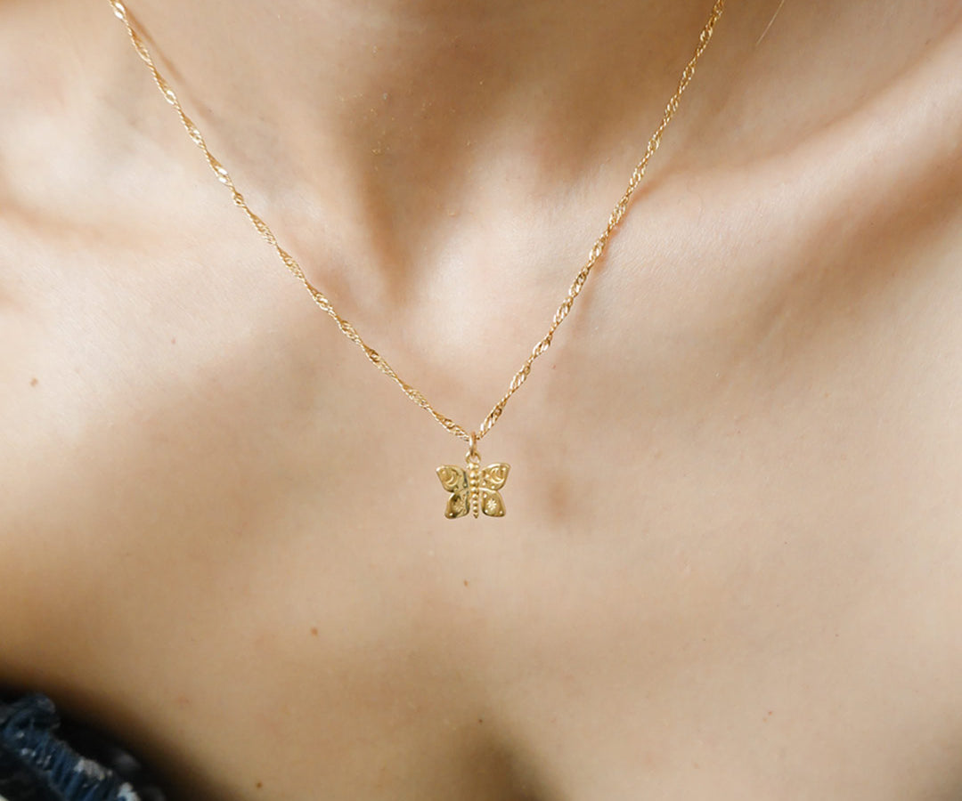 Australian gold filled jewellery butterfly charms with cosmic etchings on necklace worn by girl.
