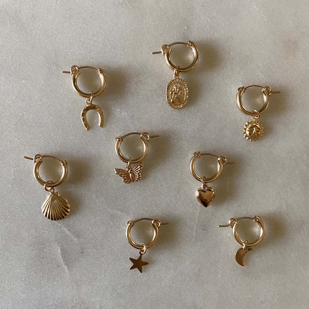 Assorted gold filled hoops with charms.