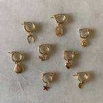 Assorted gold filled hoops with charms.