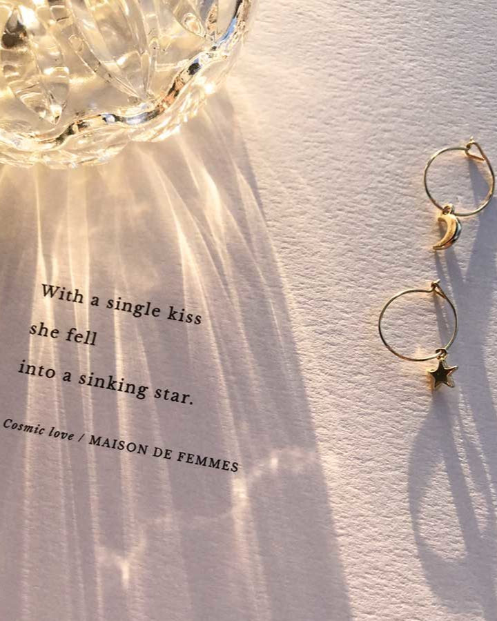 Cosmic Love poem in afternoon sunlight with earrings and a crystal jar refracting light.
