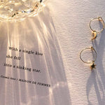Cosmic Love poem in afternoon sunlight with earrings and a crystal jar refracting light.